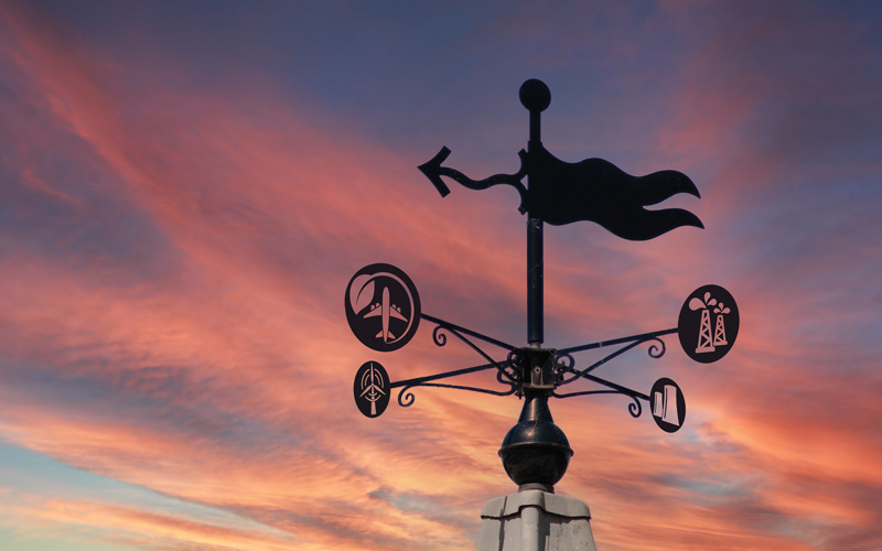 Plain modern weathervane on a roof top showing wind direction without a cockerel - Credit: Shutterstock - 143416048